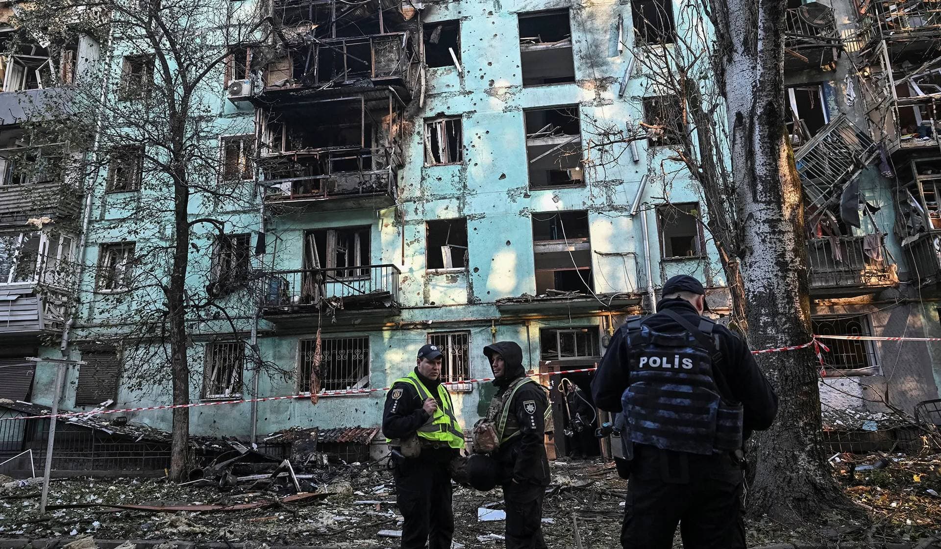 Police officers stand guard near an apartment building damaged by a Russian drone strike in Zaporizhzhia