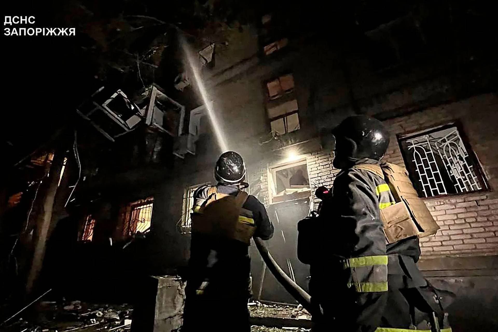 Firefighters work at the site of what Ukrainian officials say is a Russian air strike in a location given as Zaporizhia Region